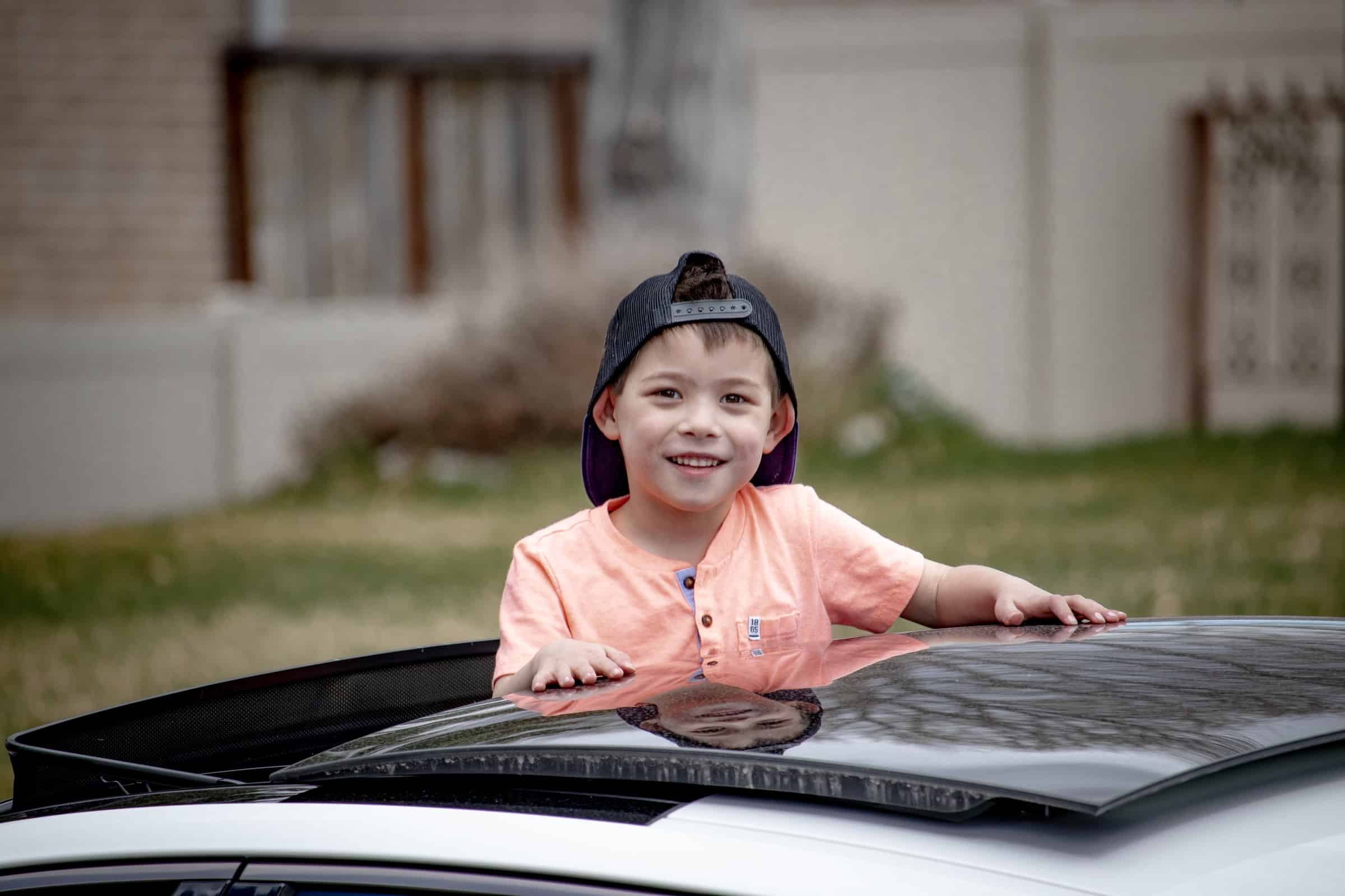 enfant dépassant du toit ouvrant d'une voiture